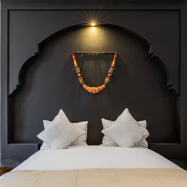 Chambre Noire de Riad Sasha, alcôve en arc laquée noire et collier de perles colorées en tête de lit